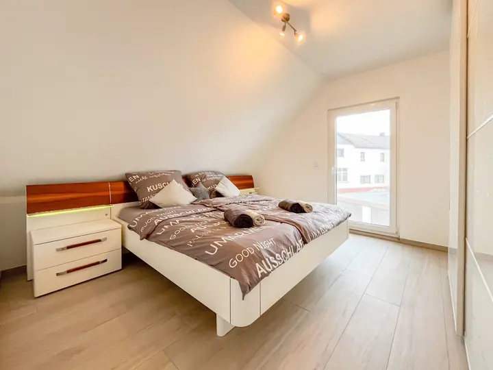 Bright main bedroom with large double bed and bedside tables