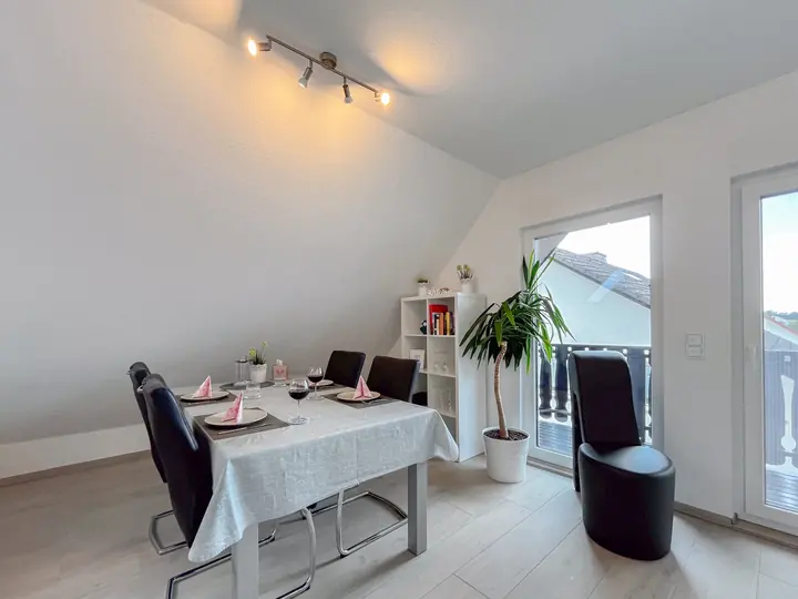 Large dining table with six seats and a wall of windows